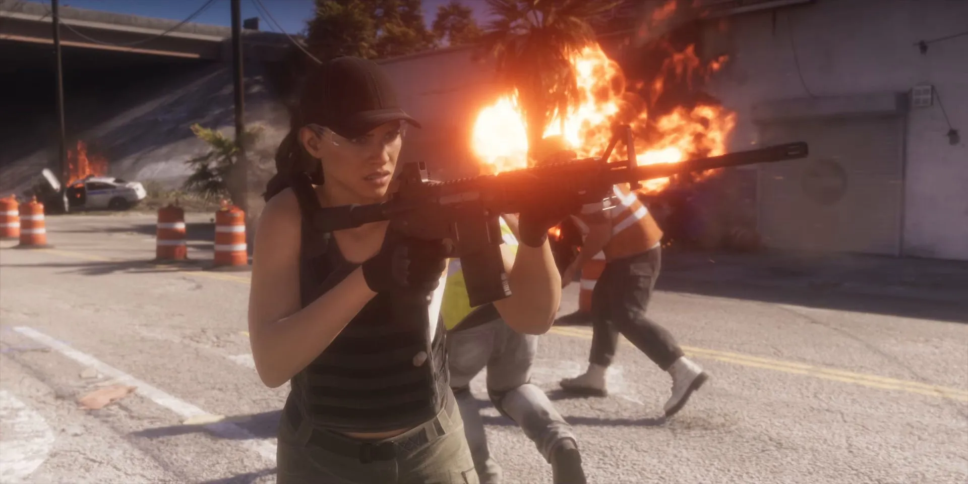 A woman in a cap fires an assault rifle in a street firefight with fire behind her