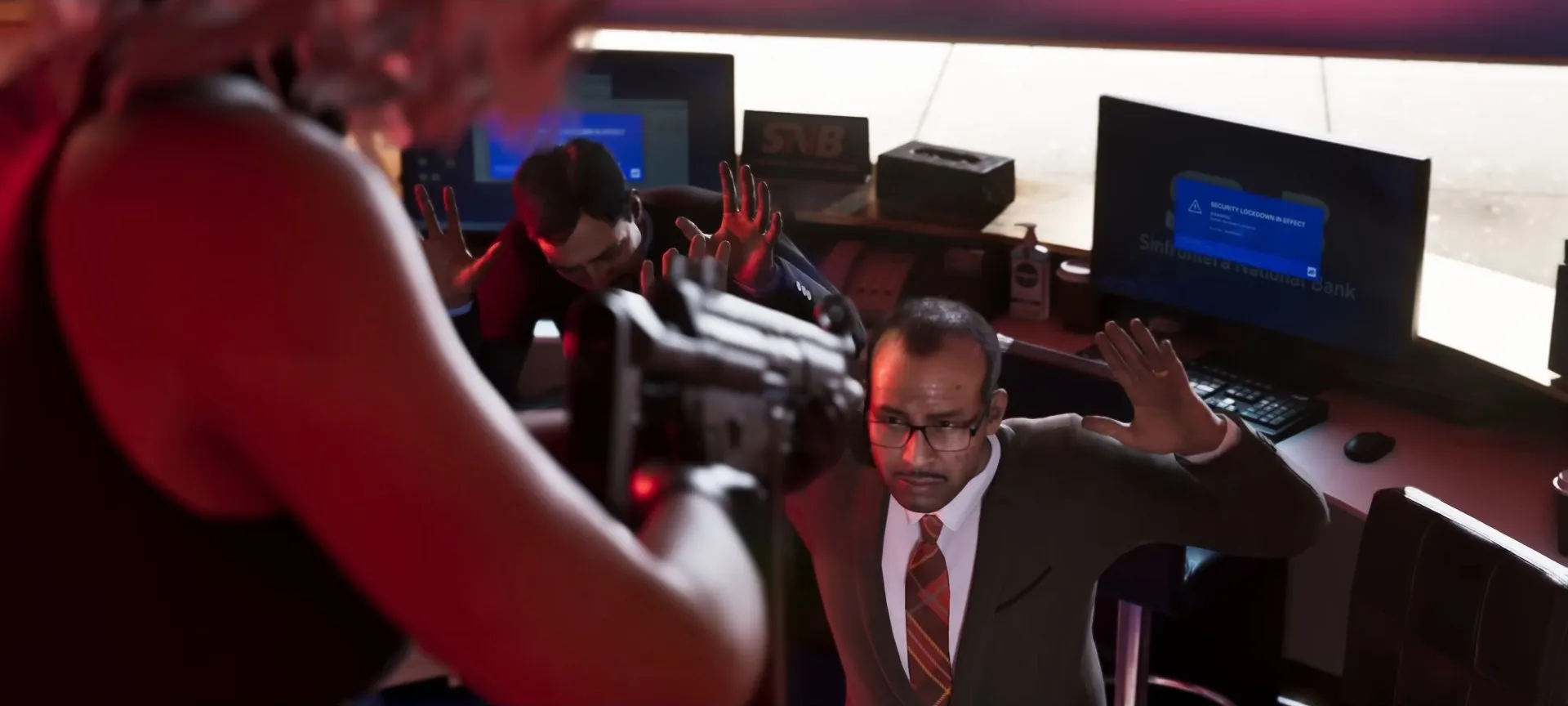 Bank employee raising his hands at a desk as a robber points a gun, a Sinfrontera National Bank screen behind him