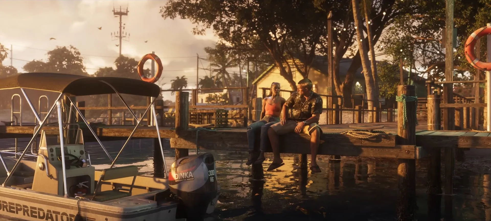 Jason and Lucia sit on a dock beside a boat at sunset